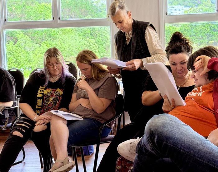 In rehearsal, reading the play script and learning lines 